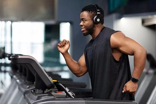 Imagem de uma pessoa usando um fone Bluetooth resistente para academia, durante um treino intenso. O fone é ergonômico, durável e de alta qualidade.
